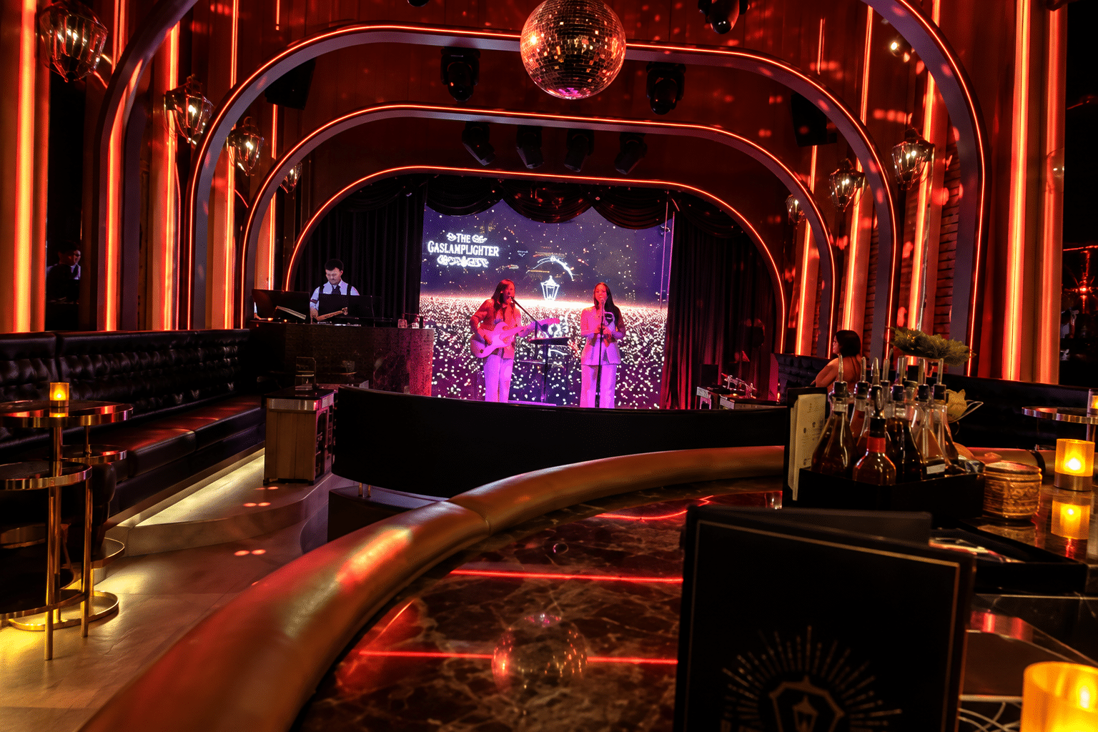 Large LED lyric screen above the karaoke stage in a downtown San Diego cocktail bar