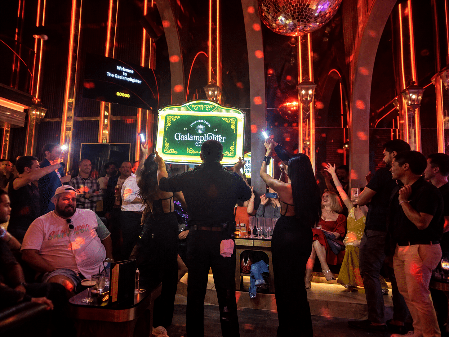 Karaoke lyric screen viewed from a velvet booth with cocktails on the table
